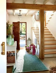 an entry way with stairs and baskets on the floor