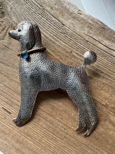 a dog brooch sitting on top of a wooden table