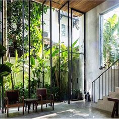 the inside of a house with glass walls and stairs