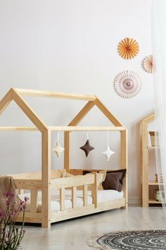 a child's bed with a wooden frame and roof shaped like a house