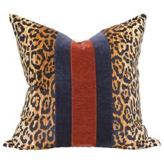 a leopard print pillow with red, blue and orange stripes on it's side