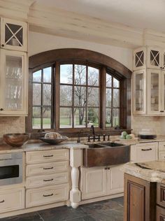 a kitchen with white cabinets and an open window above the sink is featured on instagram