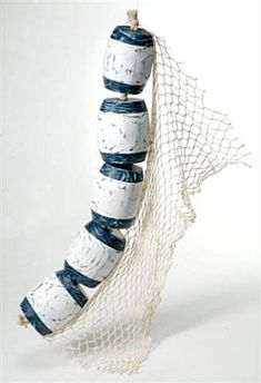 a white and blue striped object hanging from a net on a string with strings attached to it