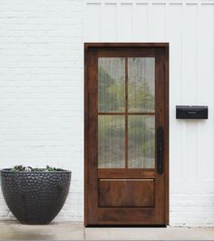 a black planter sitting next to a brown door on the side of a building