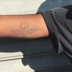 a person's arm with a small bird tattoo on the left side of their arm