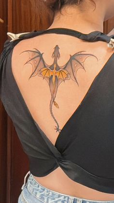 a woman with a dragon tattoo on her back