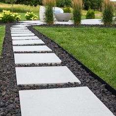 a stone path in the middle of a grassy area