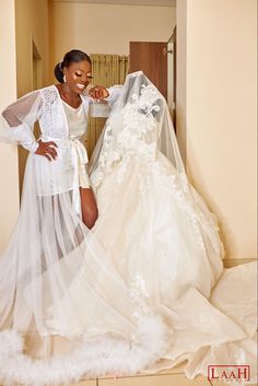 a woman is standing next to a wedding dress