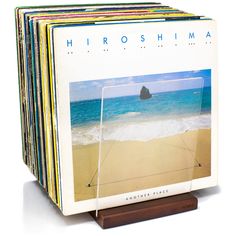 a stack of books sitting on top of a wooden stand in front of the ocean