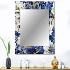 a mirror sitting on top of a wooden table next to a vase with flowers in it