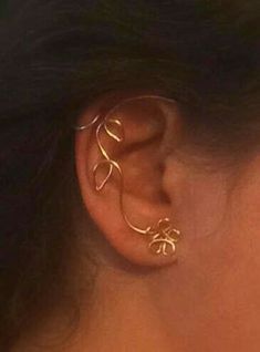 a close up of a person's ear with two gold rings attached to it