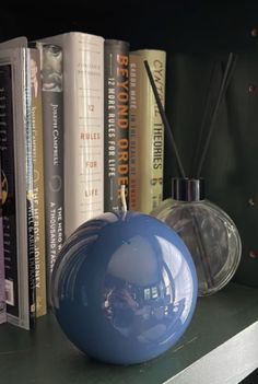 a blue vase sitting on top of a book shelf next to a bunch of books