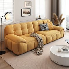 a living room with a yellow couch and white coffee table in it's center