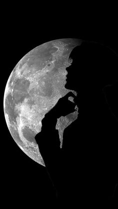 the silhouette of a person standing in front of a full moon with his hand to his face