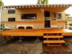 an rv parked on the side of a road with picnic tables in front of it