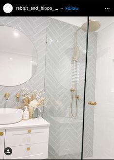 a bathroom with a sink, mirror and walk in shower next to a white cabinet