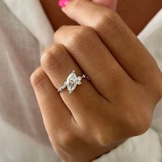 a woman's hand with a diamond ring on it