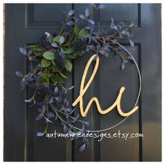 a wreath that has the letter h on it and some purple flowers hanging from it