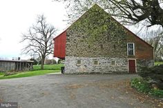 an old stone barn with a red door