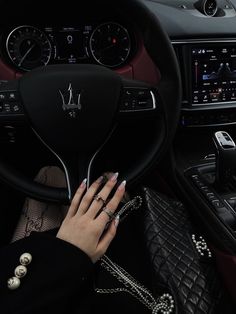 a woman is sitting in the driver's seat of a car with her hands on the steering wheel