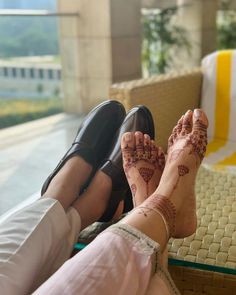 two people sitting on a couch with their feet covered in hendi