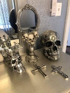 a table topped with skulls and other items on top of a wooden table next to a mirror