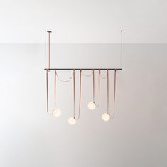 a group of lights hanging from the ceiling in a room with white walls and flooring