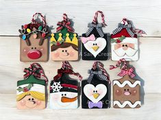 twelve handmade christmas gift tags hanging on a white wooden background with snowman, reindeer, santa claus and other holiday decorations