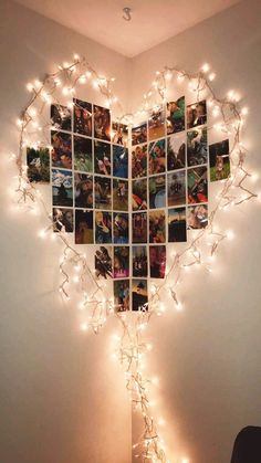 a heart shaped photo collage hanging on the wall with string lights around it and photos attached