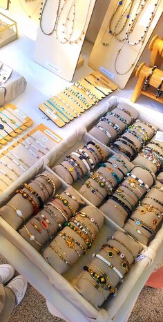 a table filled with lots of bracelets and necklaces on it's sides