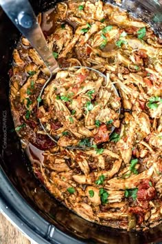 the crock pot is filled with chicken and garnished with parsley