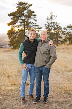 two men standing next to each other in a field