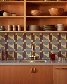 a kitchen with wooden cabinets and colorful tile backsplash