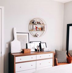 a bedroom with white walls and wooden furniture