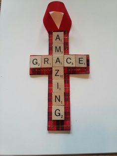 a cross made out of scrabble tiles with the word grace on it