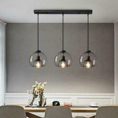 three lights hanging over a dining room table