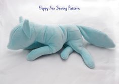 a blue stuffed animal laying on top of a white sheet with the words happy for sewing pattern