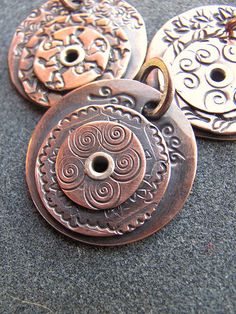 four antique style buttons are sitting on the ground