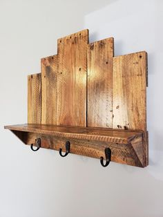 a wooden shelf with hooks on it and some wood planks hanging from the wall