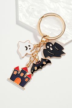 a keychain with two halloween themed items hanging from it's side on a white surface