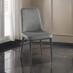 a gray chair sitting in front of a window