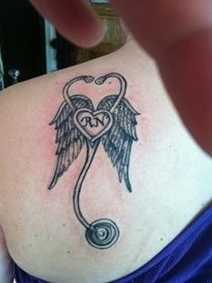 a person with a heart and wings tattoo on their back, pointing at the camera