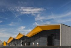 an empty parking lot next to a building with yellow awnings on the roof