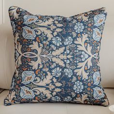 a blue and white pillow sitting on top of a couch