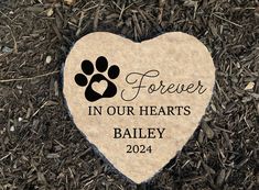 a memorial stone with a dog's paw on it in the middle of some grass