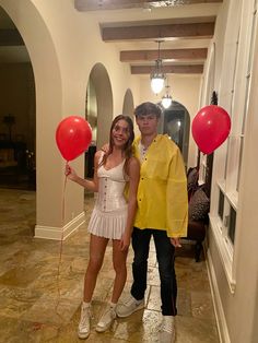 a man and woman in costumes standing next to each other with red balloons attached to them