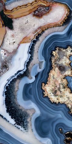 an abstract image of blue and white water with rocks in the foreground, on top of it