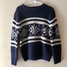 a blue and white sweater hanging on a wall