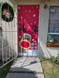 a red door decorated with a reindeer head and snowflakes on it's side