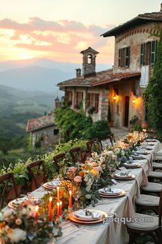 an outdoor dining table with candles and flowers in front of a house on a hillside